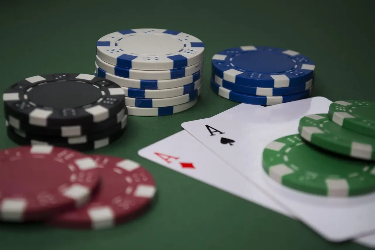 Pokermarker och två ess på ett grönt pokerbord
