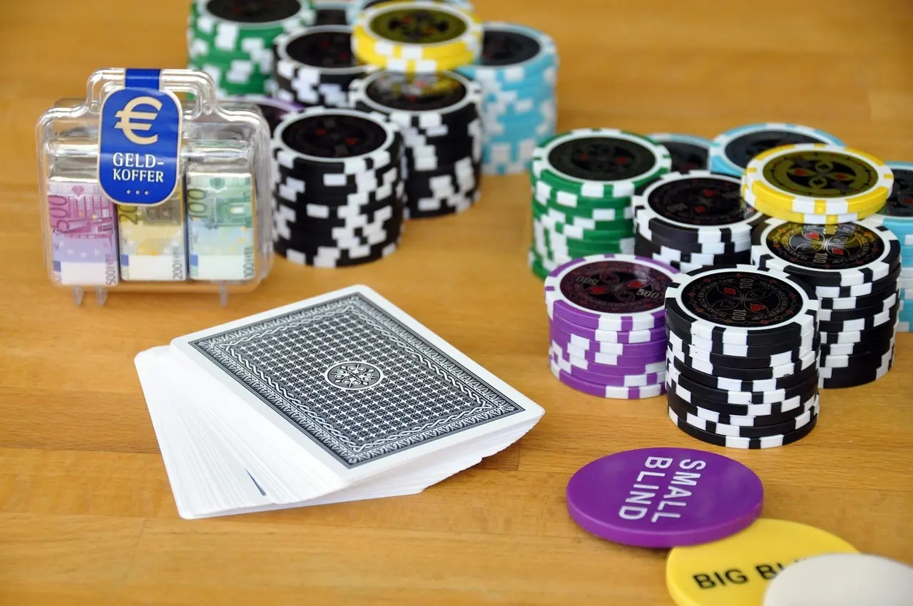Spelkort, pokermarker och blindknappar på ett bord